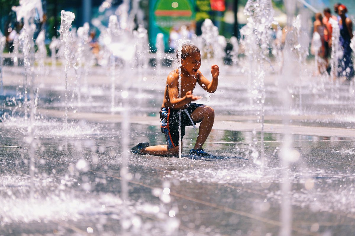 A child braces himself as a jet of cold water shoots up from the Dilworth Park's fountain.