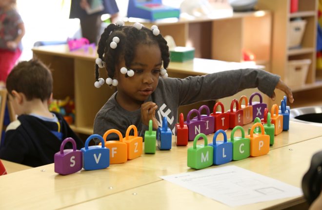 One student plays with alphabet blocks on her first day of PHLpreK.