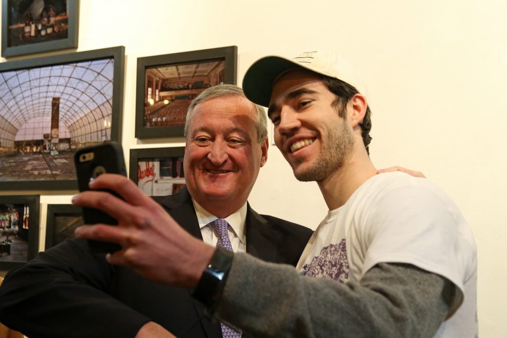 A volunteer takes a selfie with the Mayor at a service event at William Way LGBT Community Center.
