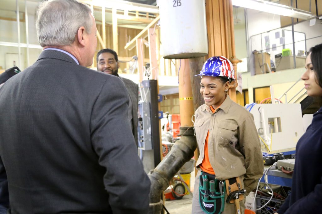 Mayor Kenney speaks to a carpentry student at Randolph CTE High School during this tour.