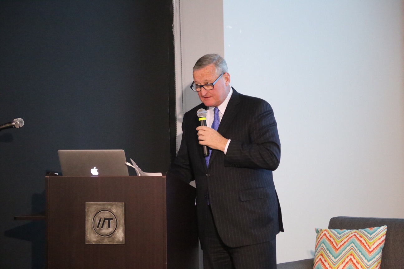 Mayor Kenney speaks at a podium while holding a microphone.