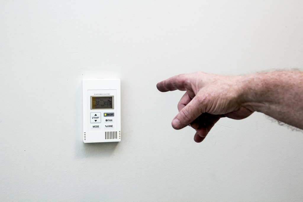 Hand pointing at a thermostat