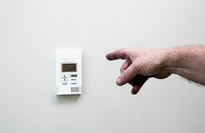 Hand pointing at a thermostat