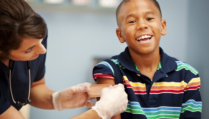 A child smiling after getting an immunization