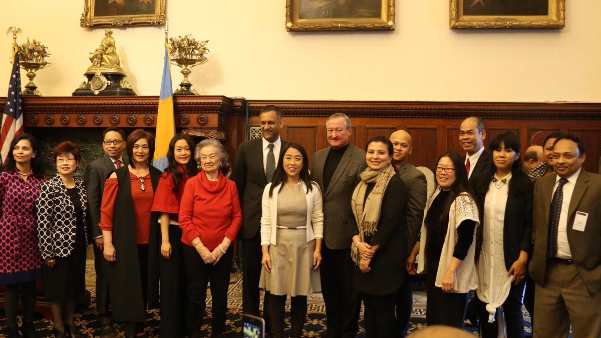 Mayor Kenney stands in the center of several local Asian American leaders at City Hall. There are portraits of all the mayors in Philadelphia history behind them.