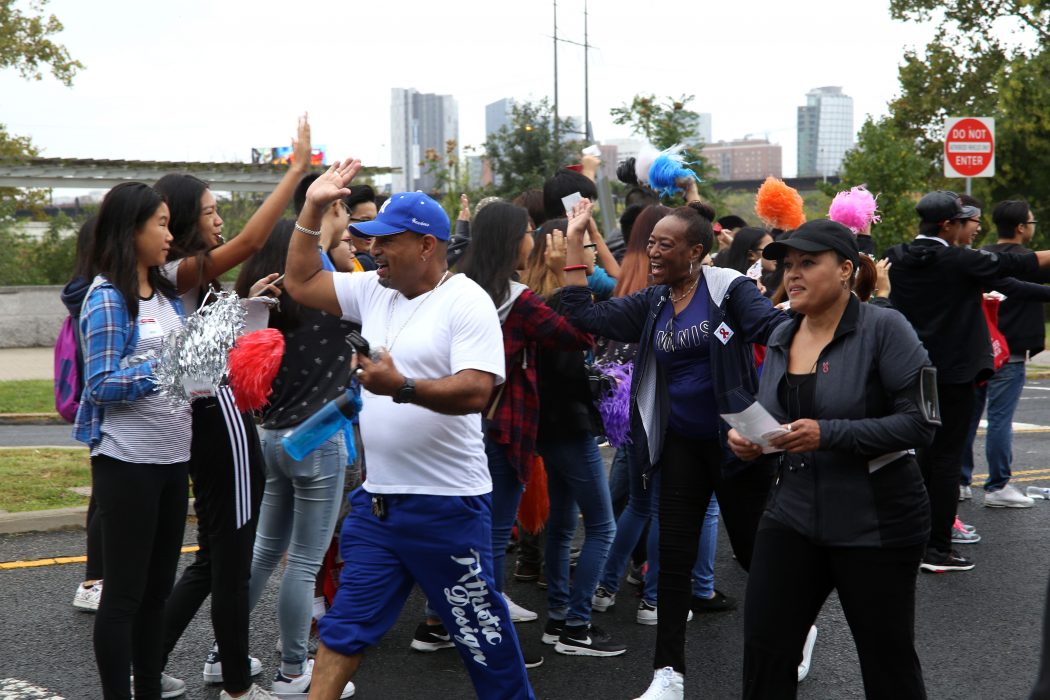 Volunteers give high fives to participants at the finish line of the AIDS Walk