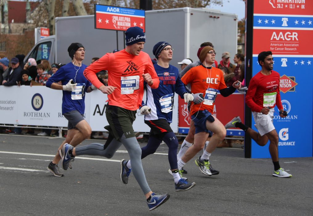 A group of participants in the half marathon keep pace in the brisk weather while onlookers cheer them on in the background