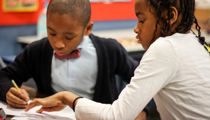 Two children working together on a writing project