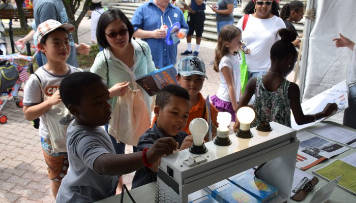 Children learning about energy efficiency through different light bulbs