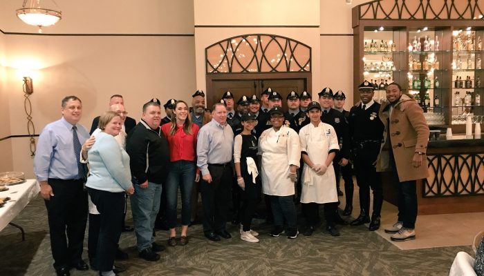 Caitlyn boyle with members of the Fraternal Order of Police Lodge 5 at the george washington high school thanksgiving feast.