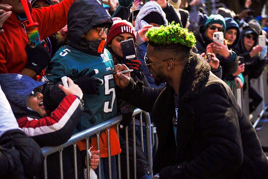 A player from the Philadelphia Eagles signs a young fan's jersey