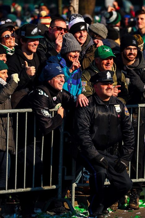 Philadelphia police officer poses for a photo with Eagles fans during the Eagles Parade