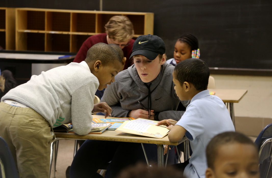 A Philly Reading Coaches volunteer helps student read.