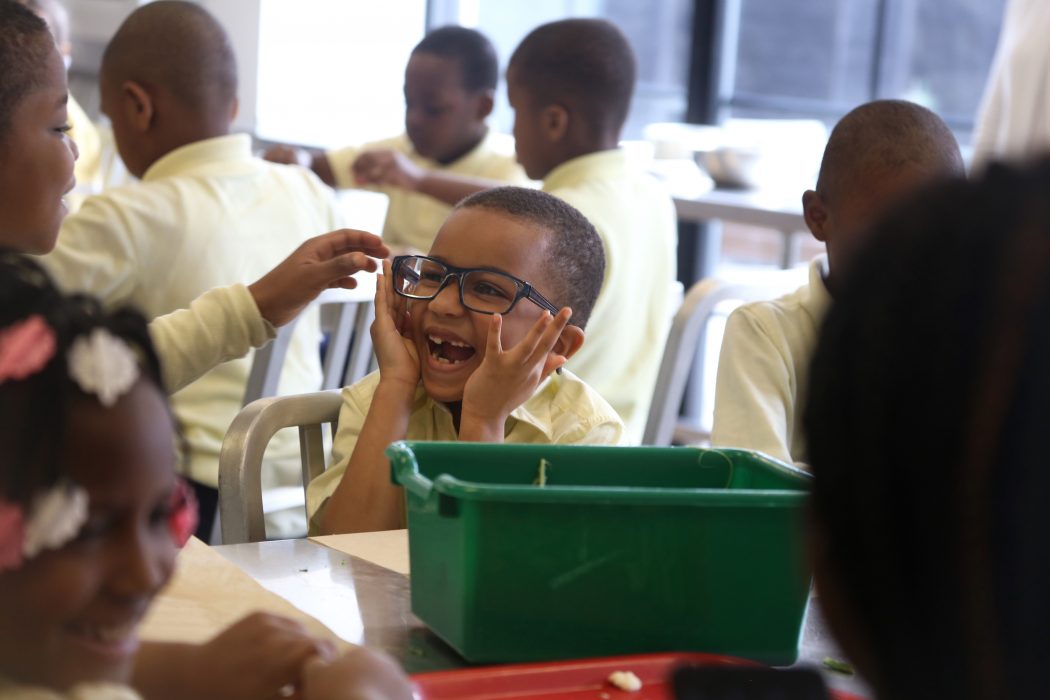 A student laughs while wearing Mayor Kenney’s glasses during a program at the Free Library on April 17.