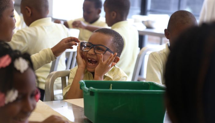 A student laughs while wearing Mayor Kenney’s glasses during a program at the Free Library on April 17.