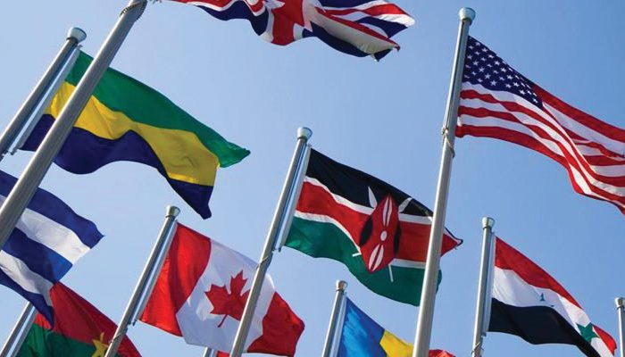Flags of many different countries wave in the wind.
