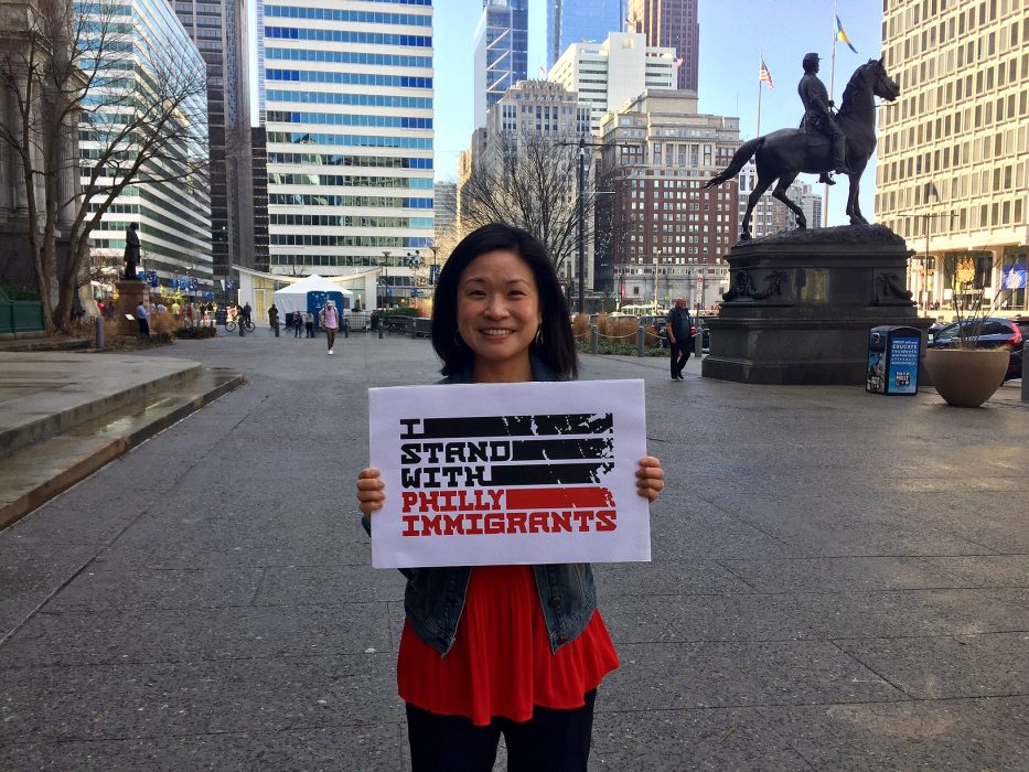 Woman holding Immigrant Heritage Month sign