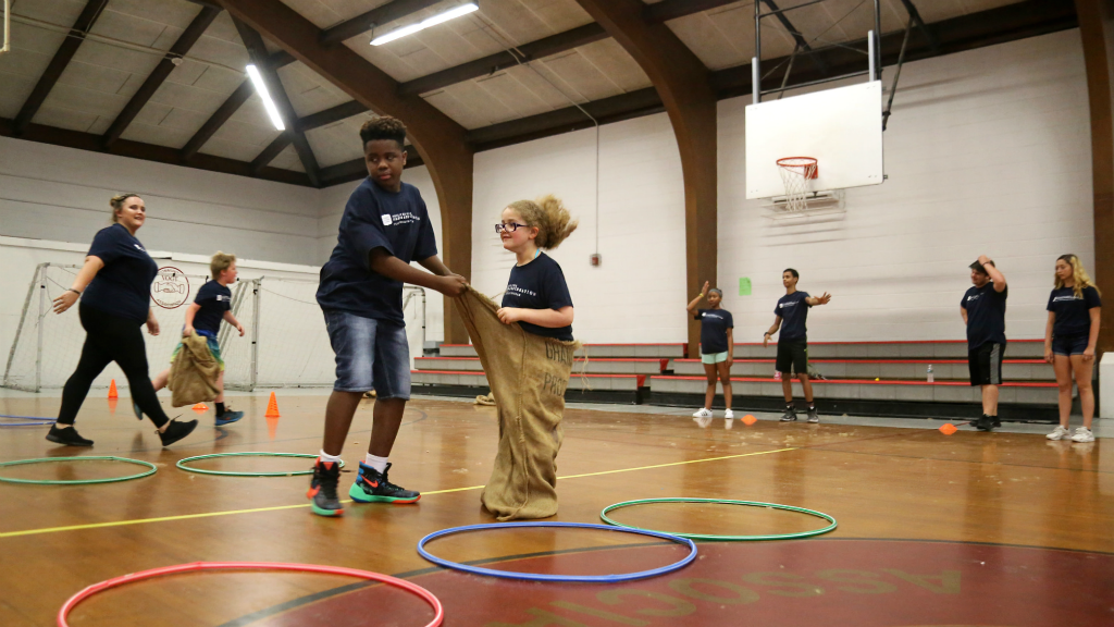 Students and coaches playing at a gym