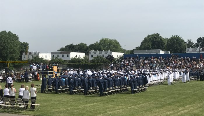 Students at Dobbins CTE High School stand for graduation