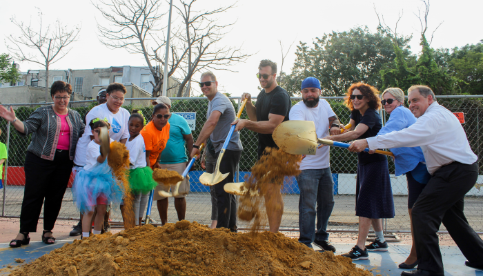 City and nonprofit leaders pose with shovels at the Waterloo Playground groundbreaking event