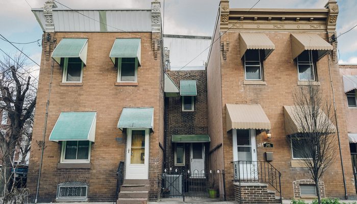 Two identical brick houses stand side by side in West Philadelphia