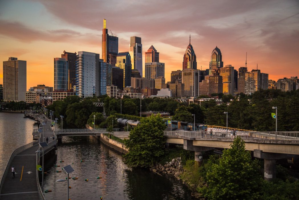 Philadelphia's skyline from the South Street Bridge with the Schuylkill River in the foreground and skyscrapers in the background.