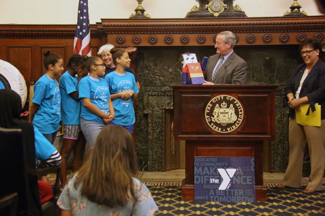 Camp Philly kids present a superhero version of Mayor Kenney to him during a press conference on July 13.