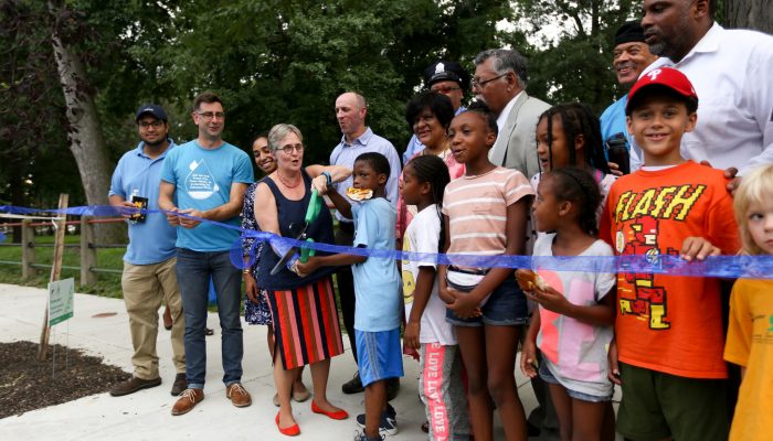 City officials and community members cutting the ribbon at Malcolm X Park