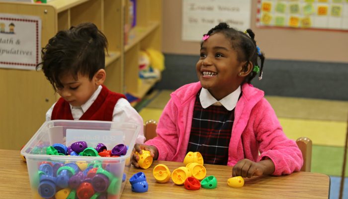PHLpreK student plays looks up and smiles