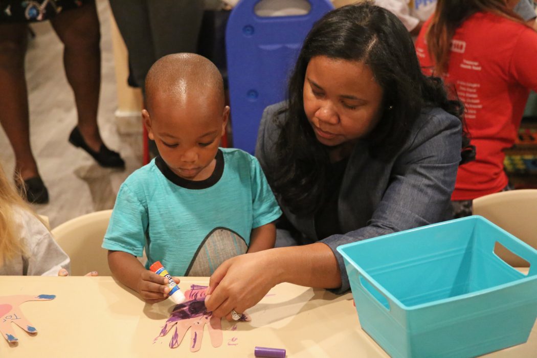 PHLpreK director Julie Beamon assists a PHLpreK student, learning