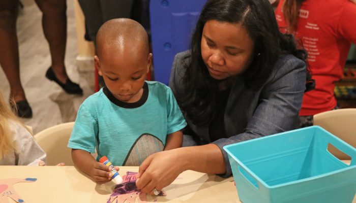 PHLpreK director Julie Beamon assists a PHLpreK student, learning