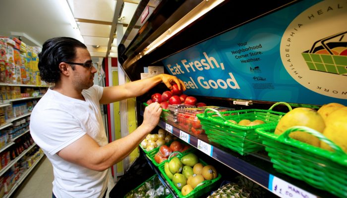 Un homme regarde des fruits dans une épicerie.