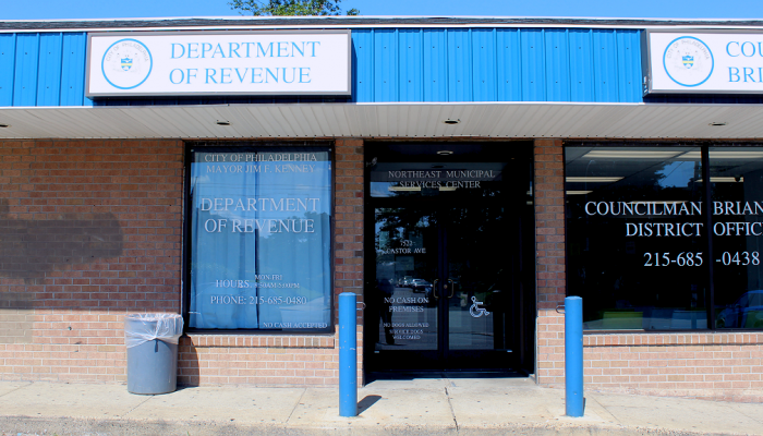 The front, glass-door entrance of the Northeast Municipal Services Center on Castor Avenue
