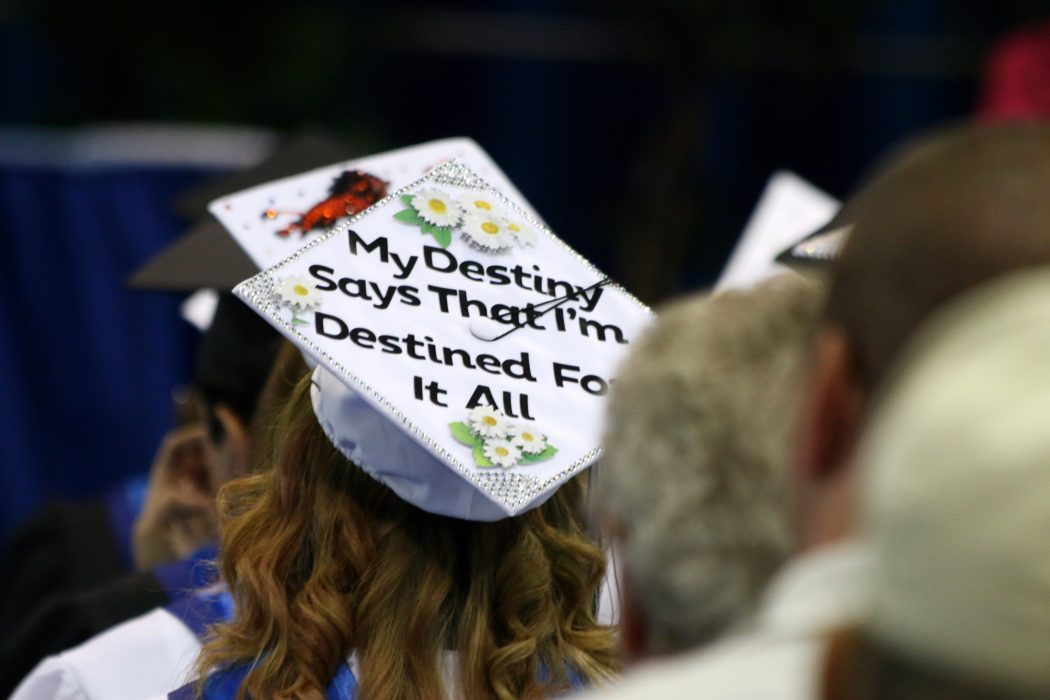 woman wearing a graduation cap that says "my destiny says that I'm destined for it all"