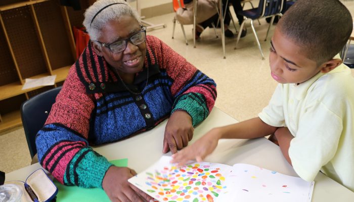 Philly Reading Coach and student read together, laugh, smile