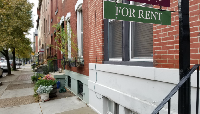 A "For Rent" sign hangs outside a brick rowhouse in South Philadelphia