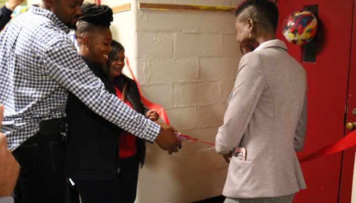 Members of the Gompers community smile, cut ribbon, at the opening of the school's Sensory Room and Community Closet