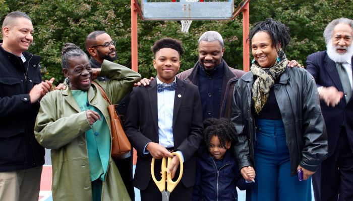 A young student cuts the ribbon at a park