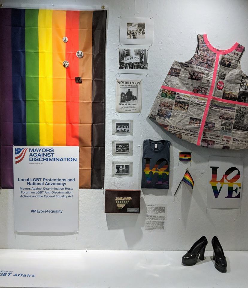 art exhibit in city hall showing different lgbtq artifacts