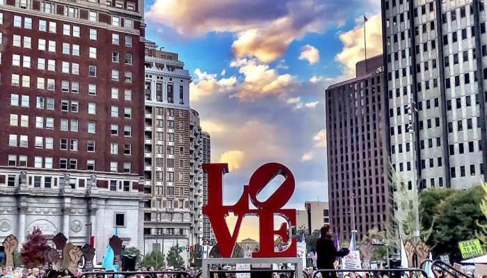 protestors gather around the love sculpture