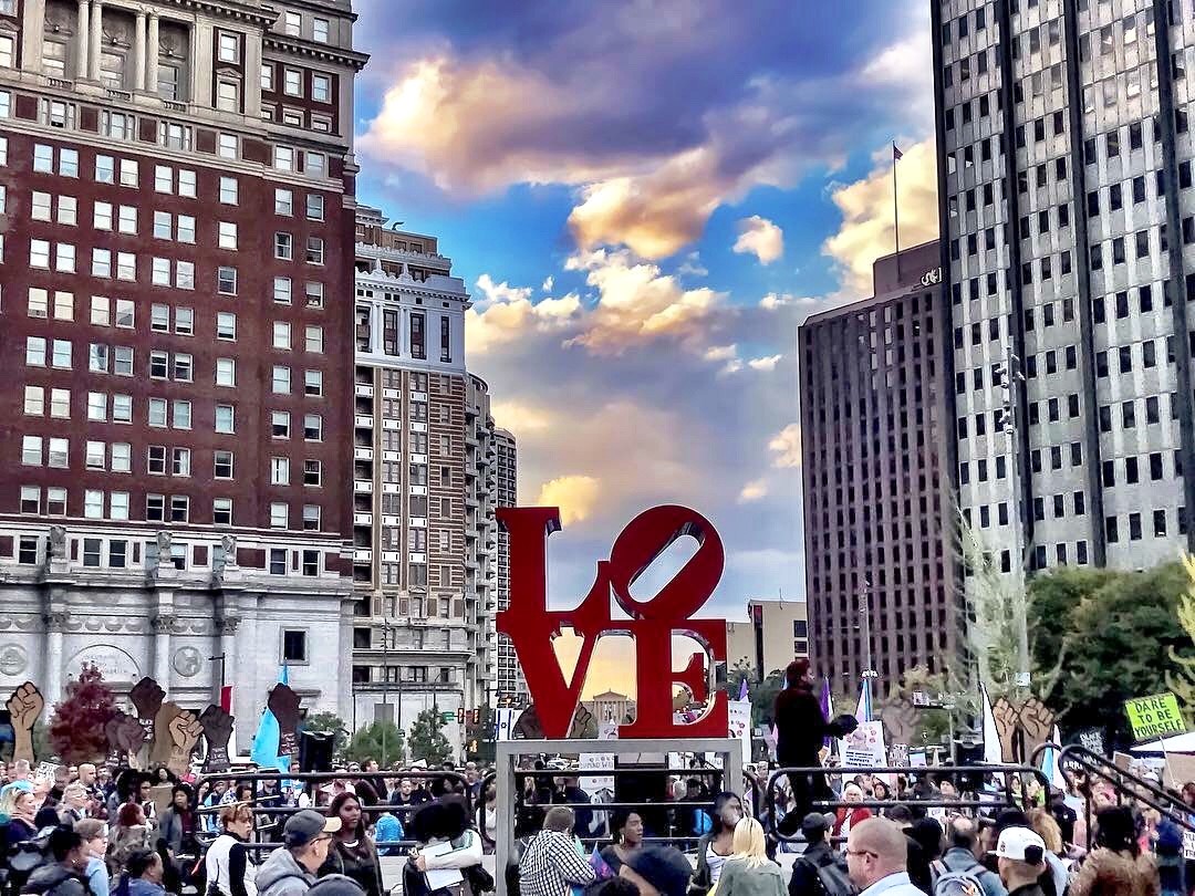 protestors gather around the love sculpture