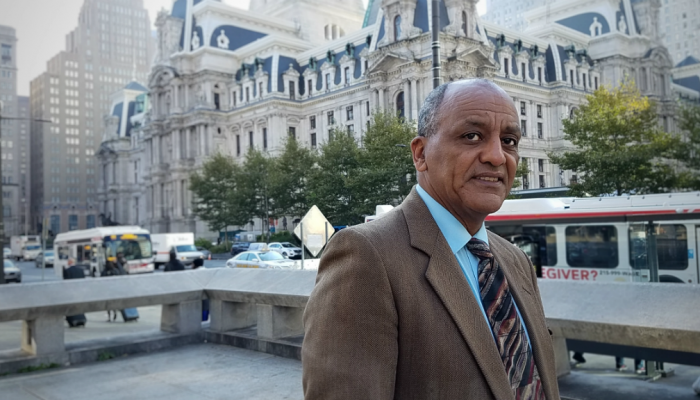 T. Afessa, Director of Policy at the Department of Revenue, stands in front of Philadelphia City Hall.