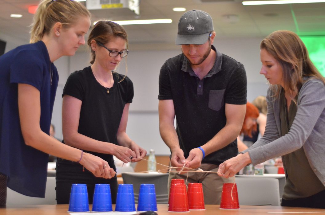 Four people stacking cups.