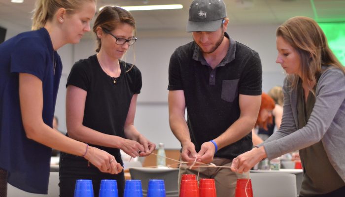 Four people stacking cups.