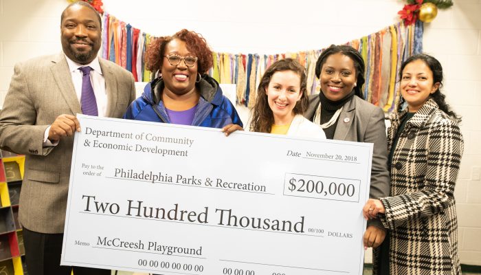 Officials at the McCreesh Playground grant announcement posing with an enlarged check