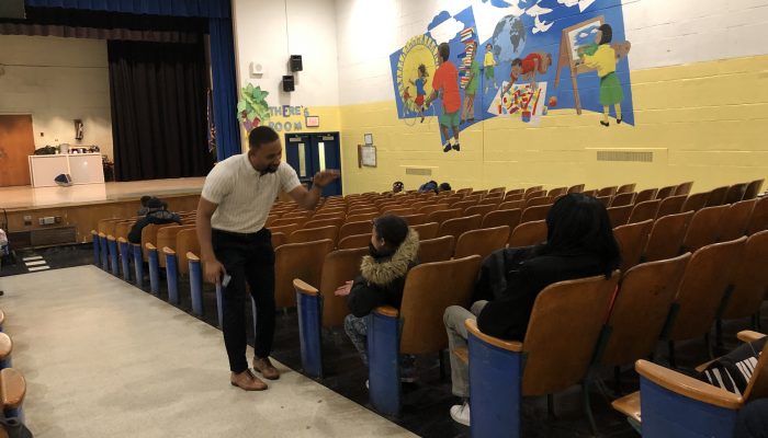 Gideon Community School Coordinator Greg Wright high fives a student