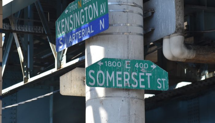 Street signs with Kensington on one and Somerset on another underneath the Market-Frankord El.