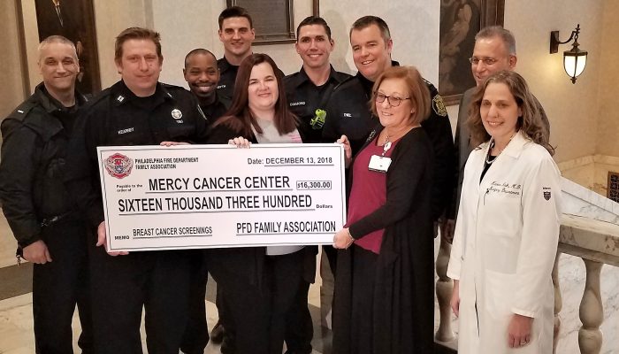 Group holding giant check for $16,300