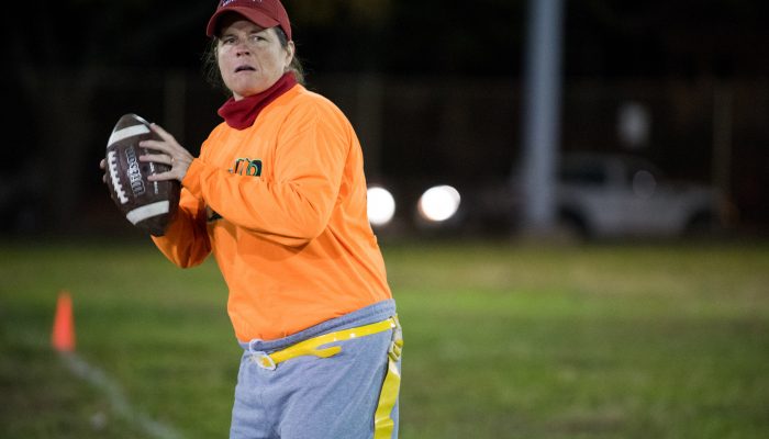 A player holds a football on the field at Tarken Playground