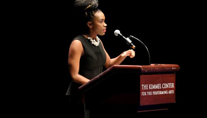 amber hikes speaking from a podium at the lgbtq state of the union